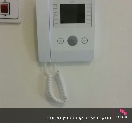 אינטרקום עם מסך ולחצנים על קיר